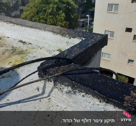כבלים שחורים על גג ליד דוד שמש